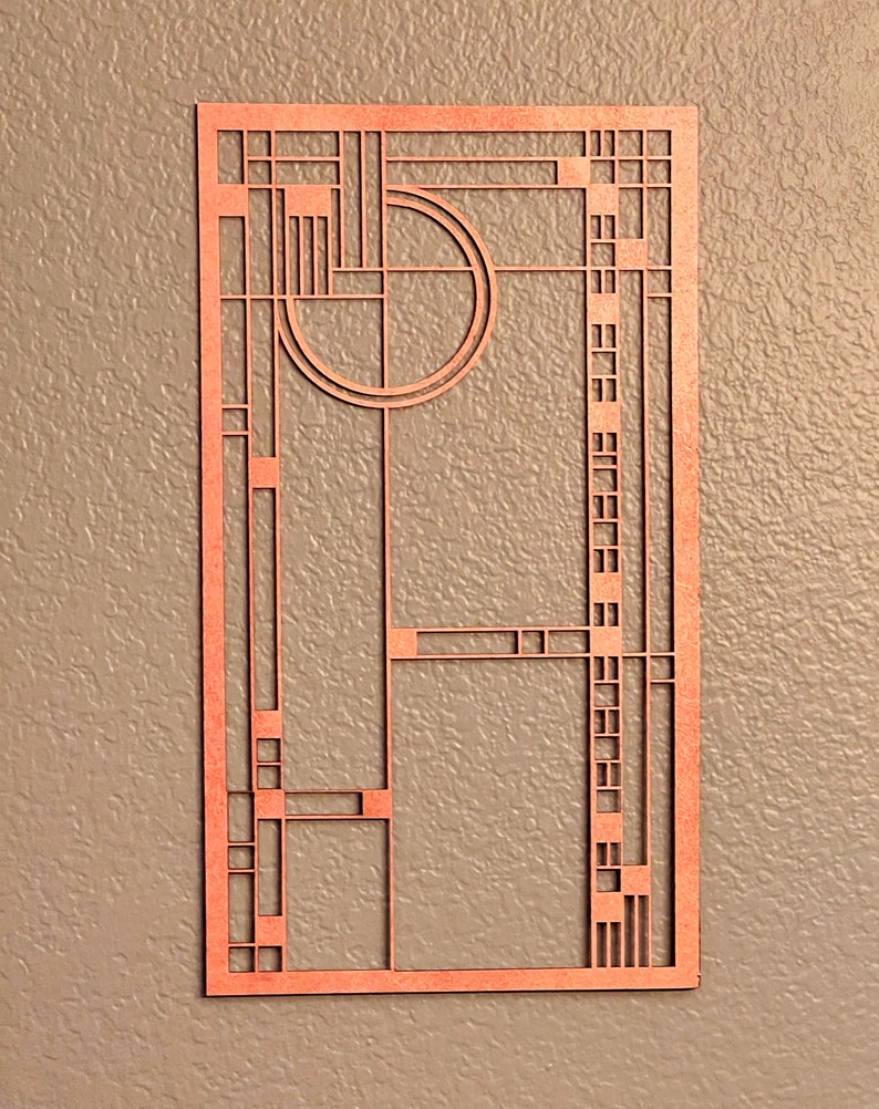 Puede incluir: Una decoraci&oacute;n de pared de madera con un dise&ntilde;o geom&eacute;trico en color marr&oacute;n rojizo. El dise&ntilde;o presenta un c&iacute;rculo con un c&iacute;rculo m&aacute;s peque&ntilde;o en su interior, y una serie de cuadrados y rect&aacute;ngulos.