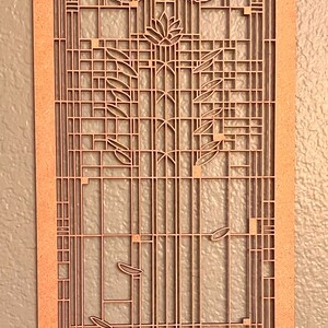 Może przedstawiać: Drewniana dekoracja ścienna z geometrycznym wzorem przedstawiającym stylizowany motyw kwiatowy. Projekt przypomina styl Art Nouveau.