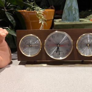 May include: A white ceramic mug with a black handle and the text "But First, Coffee" in a handwritten style. The mug is on a white surface. The mug is approximately 4 inches tall.