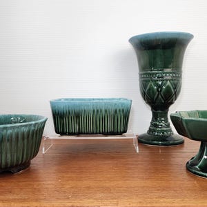 May include: Four green glazed ceramic planters, two are round, one is rectangular, and one is a pedestal bowl.
