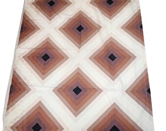 May include: A rectangular textile with a repeating geometric pattern of diamonds. The diamonds are arranged in a grid and feature a gradient of colors, ranging from light beige to dark brown, with a black square in the center of each diamond.