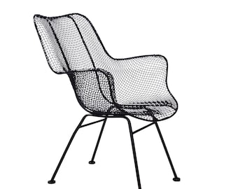 May include: A black armchair constructed from a fine metal wire mesh. The chair features a contoured, high-back seat with integrated armrests and a curved silhouette. It is supported by four thin, straight metal legs that angle outward.