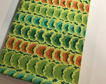 May include: Green fabric with a repeating pattern of overlapping, abstract shapes in shades of green, blue, orange, and brown.
