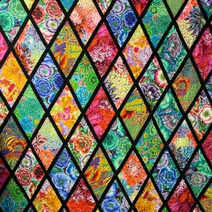 May include: A colorful quilt with a diamond pattern. Each diamond features a different floral print in shades of red, pink, blue, green, and yellow.