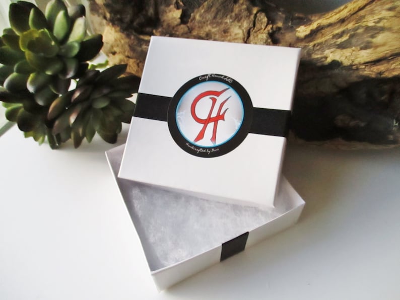 May include: White gift box with a black ribbon and a logo that says "Craft Bombells Handcrafted by Kim". The box is open and has white tissue paper inside.