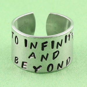 May include: A silver ring with the words "To Infinity and Beyond" engraved on it.