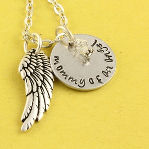 May include: Silver necklace with a charm that says "I am my mommy's angel" and a silver angel wing charm.