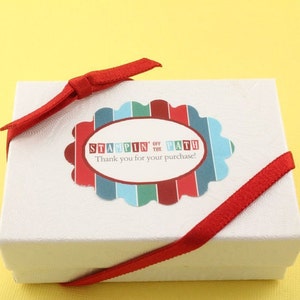 Peut inclure: Bo&icirc;te cadeau blanche avec un ruban rouge nou&eacute; autour. La bo&icirc;te a un autocollant avec le texte "Stampin' Off the Path" et "Merci pour votre achat !"