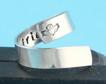 May include: Silver ring with the word "friend" engraved on one side and a Claddagh design on the other side.