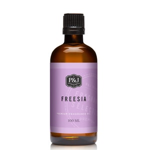 May include: A brown glass bottle with a black cap, labeled "FREESIA" fragrance oil. The label is lavender with white text and the bottle contains 100 ml of oil. The brand logo "P&J TRADING" is at the top of the label.