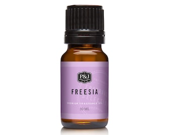 May include: A small amber glass bottle with a black cap, containing Freesia scented premium fragrance oil. The label is purple with white text that reads "P&J Fragrances" and "Freesia Premium Fragrance Oil 10 ml".