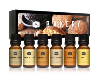 Pode incluir: Um conjunto de seis frascos de óleo essencial de 10 ml com rótulos para Bolo de Café, Biscoito de Açúcar, Pão de Mel, Snickerdoodle, Torta de Abóbora e Cupcake. Os frascos estão dispostos em uma fileira sobre um fundo branco. A caixa no fundo diz "Coleção de Fragrâncias de Padaria".