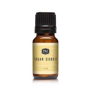 May include: A brown glass bottle with a black cap, labeled "Sugar Cookie" and "P&J Trading Co.". It is a 10 ml bottle of premium fragrance oil.