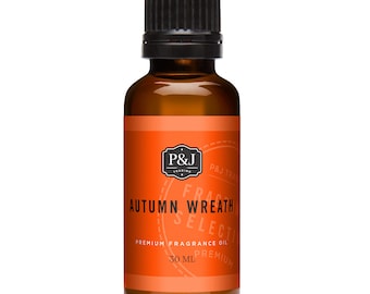 Op de afbeelding: Een 30 ml amberkleurige glazen fles met een zwarte dop. Het etiket is oranje met zwarte tekst die "P&J Trading", "Autumn Wreath", "Fragrance Oil", "Premium" en "30 ml" luidt.