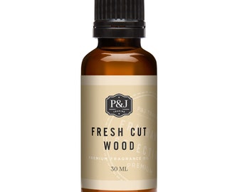 Op de afbeelding: Een bruine glazen fles met een zwarte dop, met het label "Fresh Cut Wood" en "Premium Fragrance Oil". De fles bevat 30 ml geurolie.