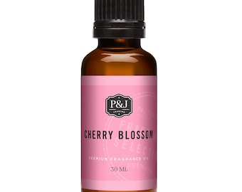 May include: A brown glass bottle with a black cap, containing cherry blossom scented fragrance oil. The label is pink with black text that reads "P&J Trading", "Cherry Blossom", "Premium Fragrance Oil", and "30 ML".