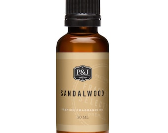 Op de afbeelding: Een bruine glazen fles met een zwarte dop, gevuld met sandelhout geurolie. Het etiket is beige met zwarte tekst die "P&J Trading", "Sandalwood", "Premium Fragrance Oil" en "30 ML" luidt.