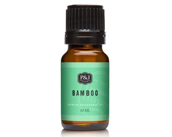 May include: A small amber glass bottle of P&J Trading Bamboo fragrance oil. The label is light green with the words "BAMBOO RANGE SELECTION" and "PREMIUM FRAGRANCE OIL" in white. The bottle contains 10 ml of oil and has a black cap.