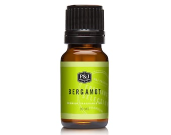 Op de afbeelding: Een 10 ml amberkleurige glazen fles Bergamot etherische olie met een zwarte dop. Het etiket is groen en wit met de tekst "P&J Trading, Bergamot Selection, Premium Fragrance Oil, 10 ml, Premium".