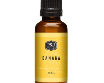 Op de afbeelding: Een 30 ml amberkleurige glazen fles met een zwarte dop. Het etiket is geel met zwarte tekst die "P&J Trading", "Fragrance Select", "Banana" en "Premium Fragrance Oil" luidt.