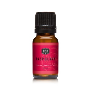 May include: A small brown glass bottle with a black cap, labeled "Raspberry Selection Premium Fragrance Oil" with a red background and white text. The bottle contains 10 ml of oil.