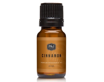 Puede incluir: Una botella de vidrio marrón con una tapa negra, etiquetada "Cinnamon Premium Fragrance Oil" por P&J Trading. La botella contiene 10 ml de aceite.