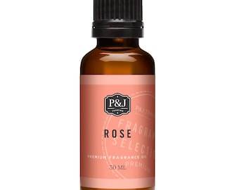 Op de afbeelding: Een bruine glazen fles rozengeurolie met een zwarte dop. Het etiket is perzik van kleur met de tekst "ROSE" en "PREMIUM FRAGRANCE OIL". De fles bevat 30 ml olie.