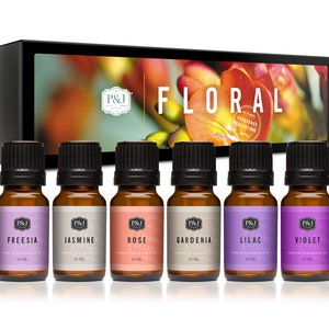 May include: A set of six 10 ml bottles of essential oils in a box. The bottles are labeled with the names of different floral scents: Freesia, Jasmine, Rose, Gardenia, Lilac, and Violet. The box is labeled "Floral Fragrance Collections".