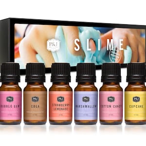 May include: Set of six 10 ml bottles of essential oil for slime. The bottles are labeled with different scents: Bubble Gum, Cola, Strawberry Lemonade, Marshmallow, Cotton Candy, and Cupcake. The bottles are arranged in a row on a white background. The image also includes a box with the text "Slime Fragrance Collection" on it.