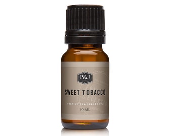 Op de afbeelding: Een bruine glazen fles met een zwarte dop die Sweet Tobacco Premium Fragrance Oil bevat. De fles is gelabeld met de tekst "P&J Fragrances" en "Sweet Tobacco Premium Fragrance Oil 10 ML".