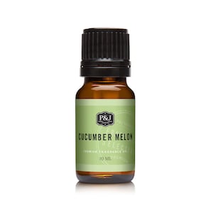 May include: A 10 ml amber glass bottle with a black cap, containing Cucumber Melon scented fragrance oil. The label is green with white text that reads "P&J Trading", "Cucumber Melon", "Premium Fragrance Oil", and "10 ml".