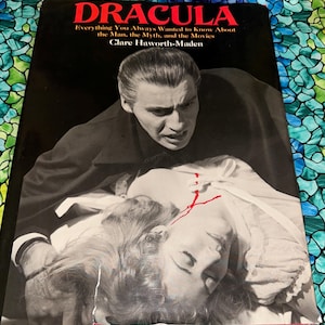 May include: A book cover featuring the title "DRACULA" in red letters above a black and white image of a man and woman. The text "Everything You Always Wanted to Know About the Man, the Myth, and the Movies" is also visible. The author's name is Clare Haworth-Maden.