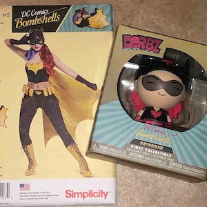 May include: A Simplicity sewing pattern and a Dorbz vinyl collectible figure. The pattern features a Batgirl costume design from DC Comics Bombshells. The collectible is a Batwoman figure in a box.