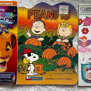 May include: Three coloring books featuring Disney's The Lion King, Peanuts, and Girls. The Lion King book has a colorful cover with Simba and Nala. The Peanuts book has a fall theme with Charlie Brown and Snoopy. The Girls book has a pink cover with a variety of images including a girl on roller skates.