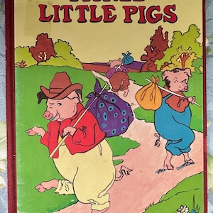 May include: A vintage children's book cover titled "THREE LITTLE PIGS." The illustration depicts three anthropomorphic pigs walking on a path, each carrying a bundle. The pigs are wearing clothes and the background features trees and a green field.