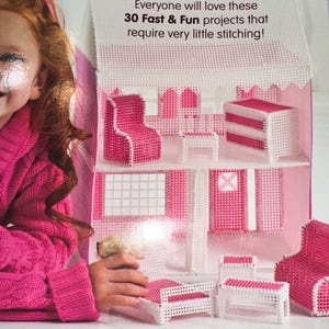 May include: A pink and white dollhouse with miniature furniture. The text reads, "Everyone will love these 30 Fast & Fun projects that require very little stitching!" The furniture includes chairs, a bed, and a table.