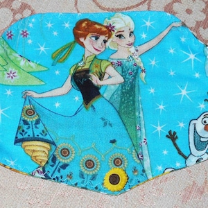 May include: A blue fabric headband with a white lace trim and a colorful print featuring characters from the movie Frozen. The print includes Elsa, Anna, Olaf, and a snowflake design.