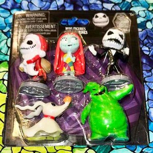 May include: A set of six Nightmare Before Christmas mini figures. The figures are Jack Skellington, Sally, Zero, Oogie Boogie, and two versions of Jack Skellington. The figures are packaged on a card with a purple background and the text "Mini Figures" printed on it.