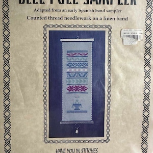 May include: A vintage cross-stitch sampler kit featuring a bell pull design. The kit includes a linen band, counted thread needlework, and a bell pull. The packaging features the title "Bell Pull Sampler" and the text "Adapted from an early Spanish band sampler. Counted thread needlework on a linen band." The packaging also includes the company name "Have You In Stitches" and contact information.