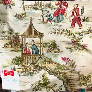 May include: Cream-colored fabric with a detailed Asian-inspired toile design. The fabric features scenes of people, pagodas, bridges, and foliage in shades of red, blue, green, and brown. The fabric has a tag that says "Red Tag Discontinued Sample" and "WAVERLY".