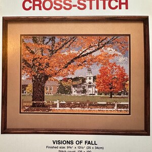 May include: A Holbert Cross-Stitch kit titled Visions of Fall, featuring a framed cross-stitch design of a church surrounded by autumn trees. The finished size is 9 3/4 inches by 13 1/2 inches, with a stitch count of 135 by 190 stitches.