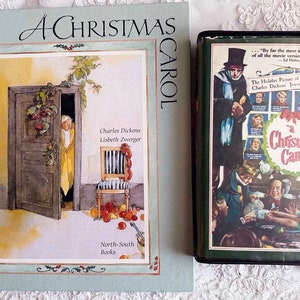 May include: A green and blue book titled "A Christmas Carol" by Charles Dickens and illustrated by Lisbeth Zwerger. The book cover features a watercolor illustration of a door with a woman peeking out. The book is published by North-South Books.