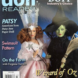 May include: A magazine cover featuring two dolls: one in a pink gown and silver crown, the other a green-skinned witch in black. Text includes "doll READER," "PATSY," "Wizard of Oz," and "DOTY." The cover is dated July 2005.