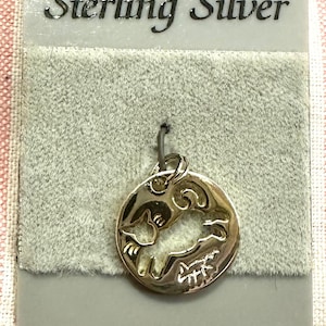 May include: A gold-toned sterling silver charm featuring a cutout design of two birds in flight. The charm is displayed on a gray background with the text "Sterling Silver" printed on a white tag.