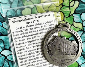 May include: A silver-toned metal medallion with a cutout of a house and the text "Welles-Shipman-Ward House 1755" and "Glastonbury, Connecticut".