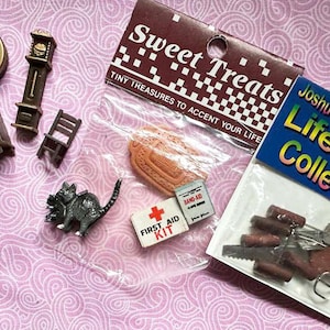 May include: A collection of miniature dollhouse accessories, including a clock, chair, dresser, and a black cat figurine. Packaged items include a first aid kit, a shoe, and miniature tools. The packaging reads "Sweet Treats" and "Joshua's Lifestyle Collectibles."