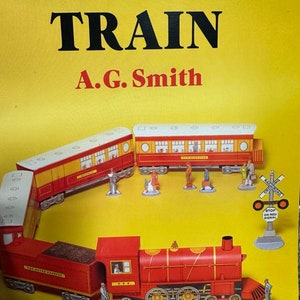 May include: A red and yellow paper model train set with a locomotive, passenger cars, and a crossing sign. The title of the book is "Easy-to-Make TRAIN" by A.G. Smith.