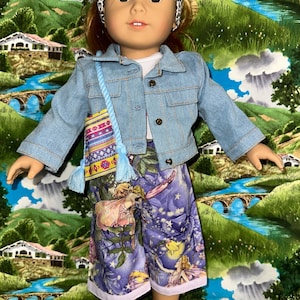 May include: A doll wearing a denim jacket, fairy-themed shorts, and a patterned purse. The shorts are purple with fairy illustrations. The purse has a blue strap and tassels. The doll has a patterned headband.