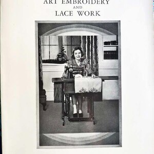 May include: A black and white photo of a woman sitting at a sewing machine. The woman is wearing a dress and has her hair pulled back. The sewing machine is on a table with a white cloth on top. The text on the page reads "Singer Instructions for Art Embroidery and Lace Work".