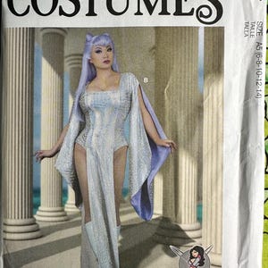 May include: McCall's Costumes pattern featuring a woman in a silver and blue fantasy costume. The costume includes a bodysuit, cape, and boots. The pattern is labeled M8187, size A5 (6-8-10-12-14).